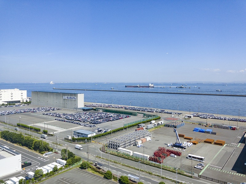 展望室から見下ろす川崎港の埠頭。自動車のヤードや大型クレーン、遠くの海に浮かぶ船が見える