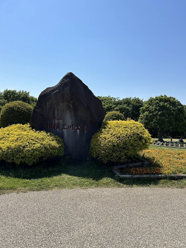青空の下、県立相模三川公園の入口にある「県立相模三川公園」と刻まれた石碑